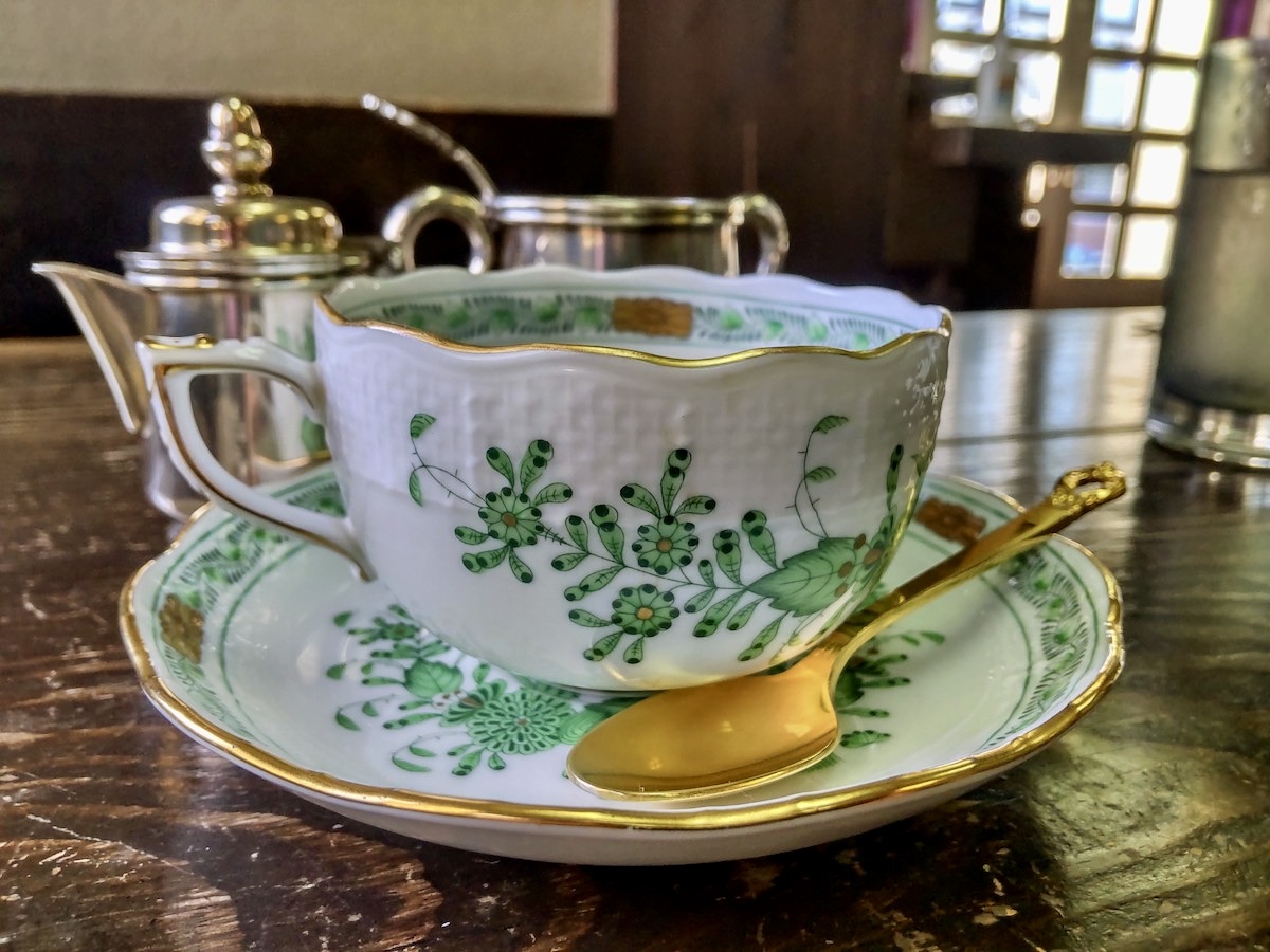 A cup of coffee served in a beautiful green Herend porcelain cup