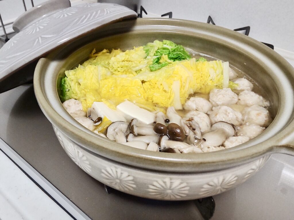 Napa cabbage, tofu, shimeji mushrooms, and chicken in a hot pot.