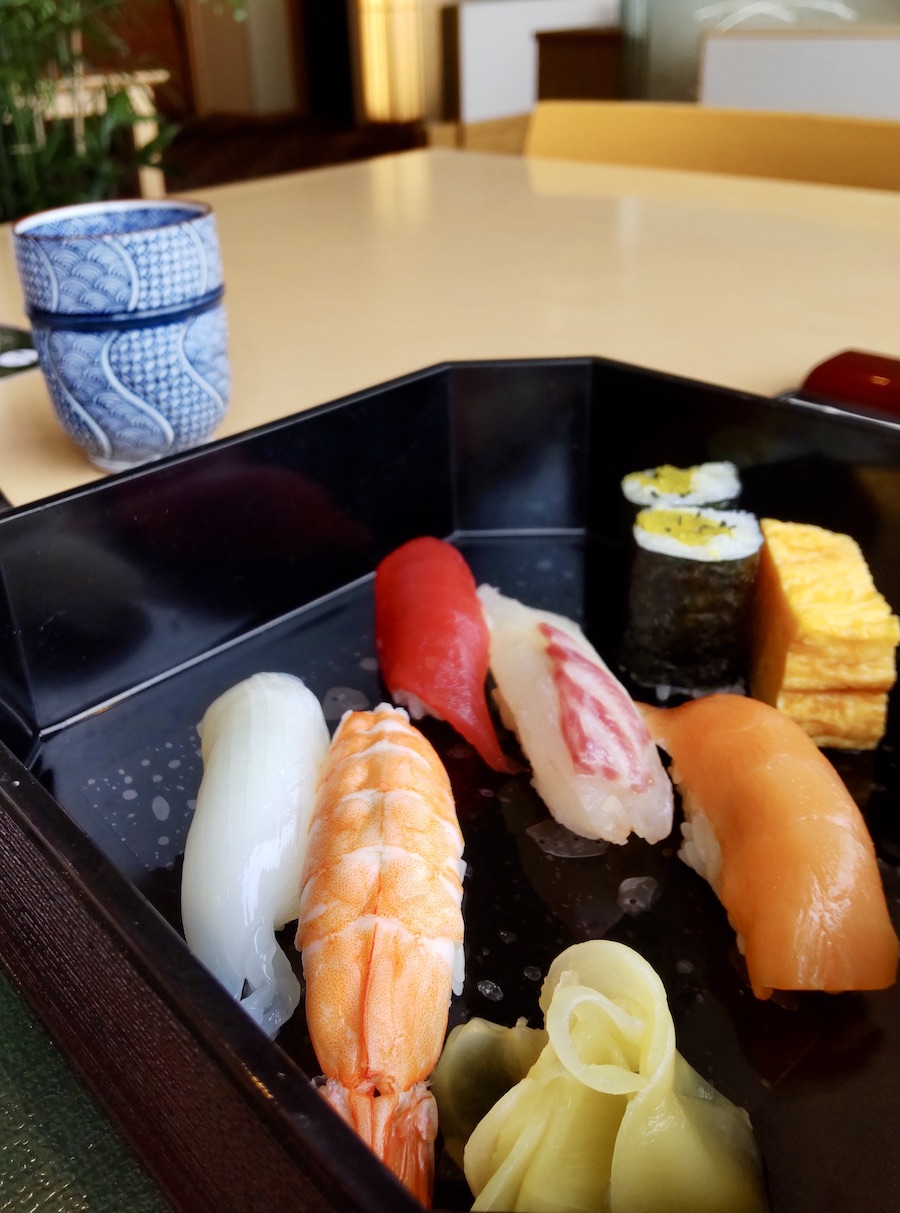 Assorted sushi in a square wooden box.