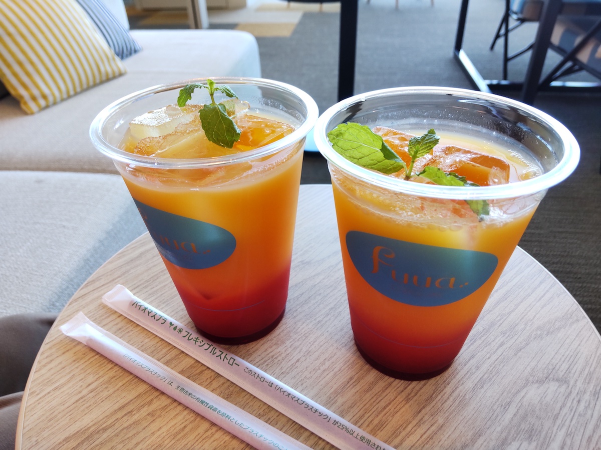 Two-layered orange and red drink topped with a fresh green mint leaf