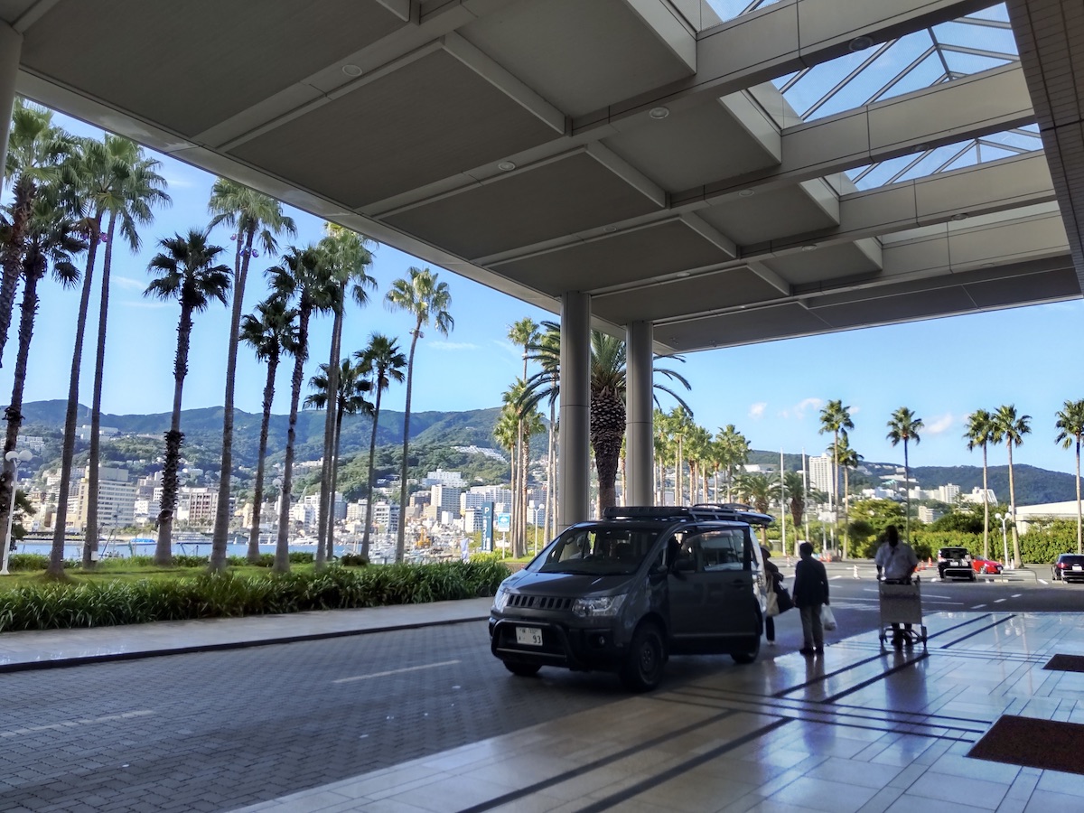 A spacious hotel terminal with views of palm trees, mountains, and sky