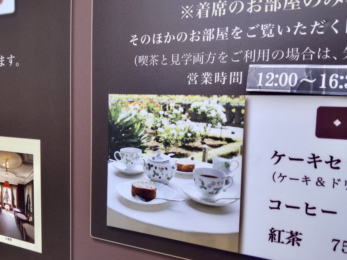 A sign displaying a photo of a tea and cake set