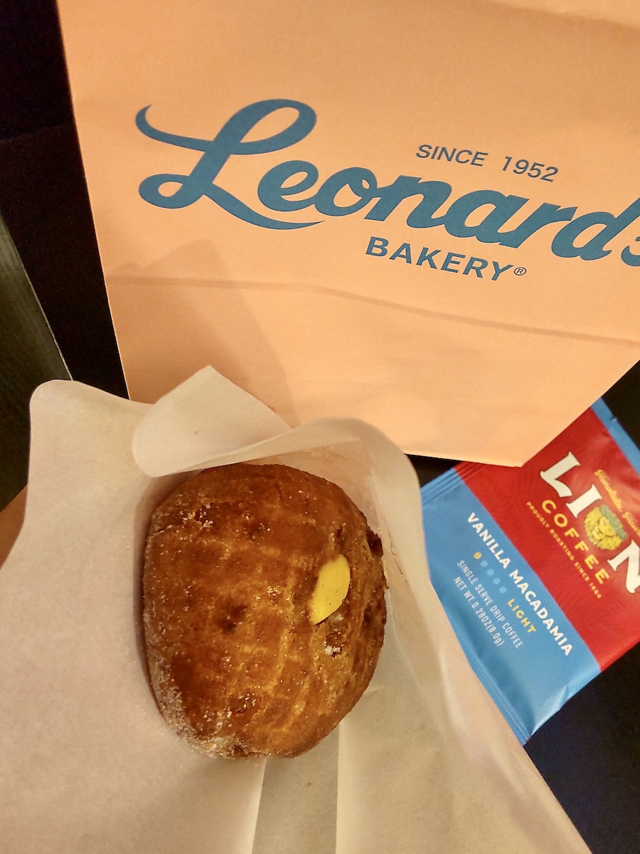 Custard-filled sugar donut with a red pack of drip coffee