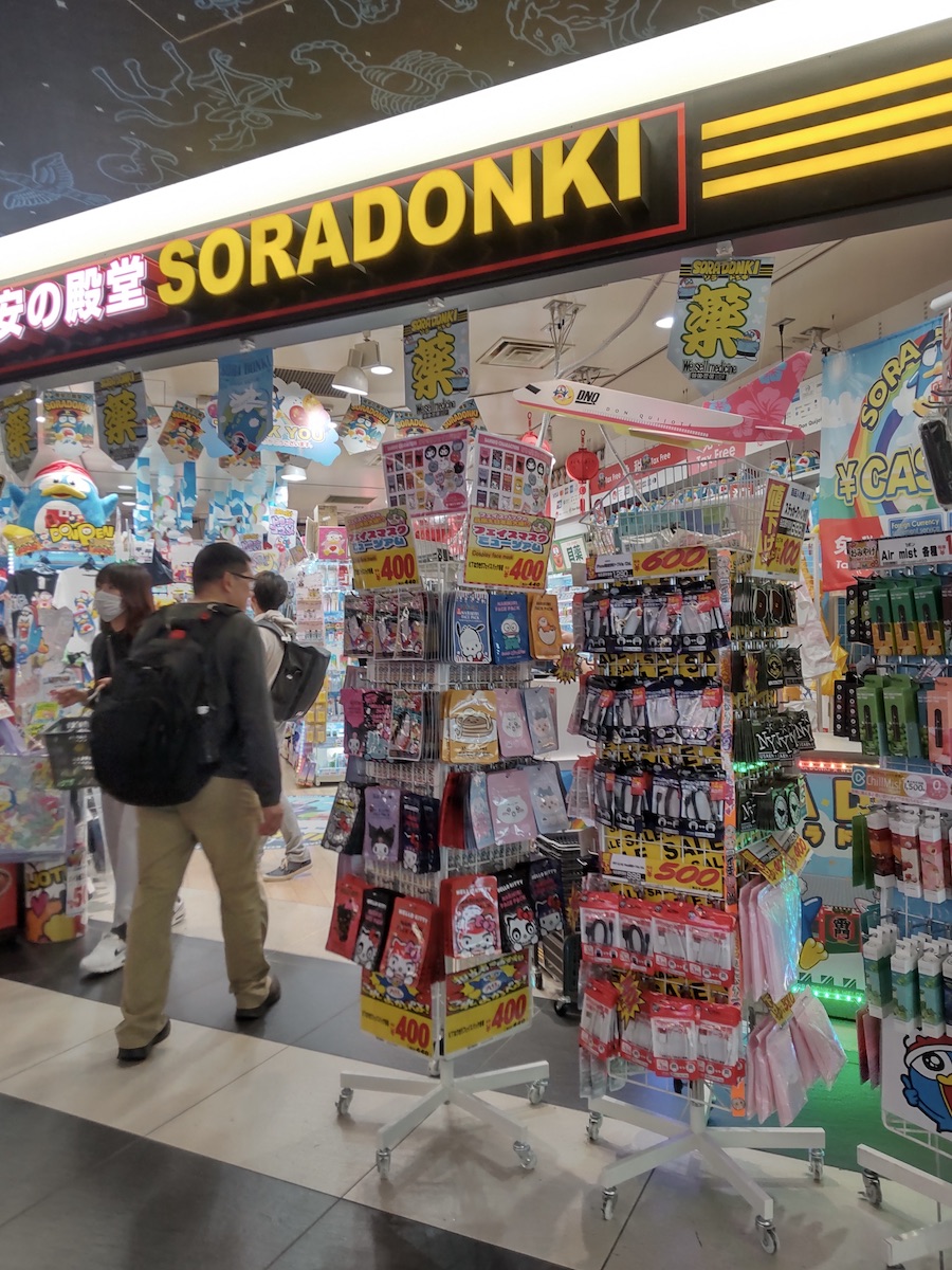 A store with a flashy exterior and a variety of products densely packed at the entrance