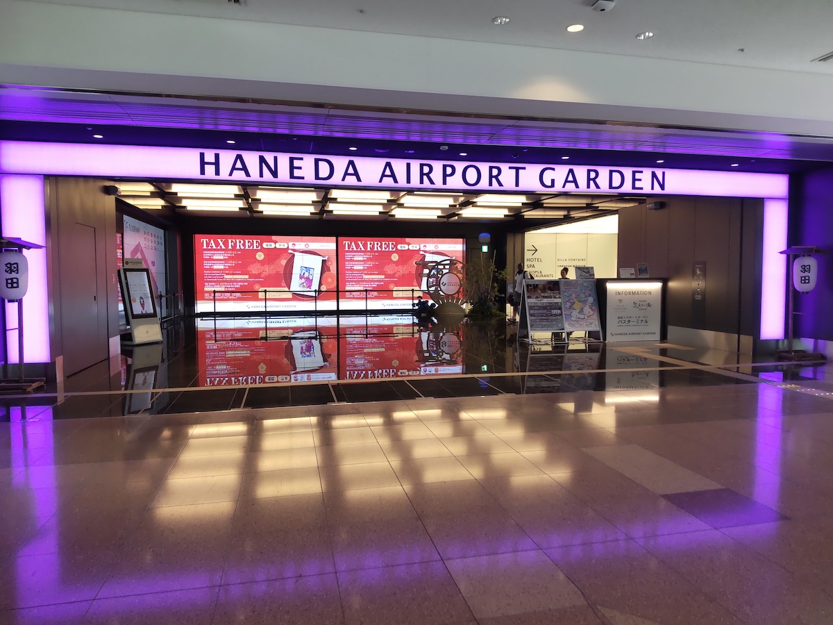A purple-lit entrance gate featuring the text Haneda Airport Garden