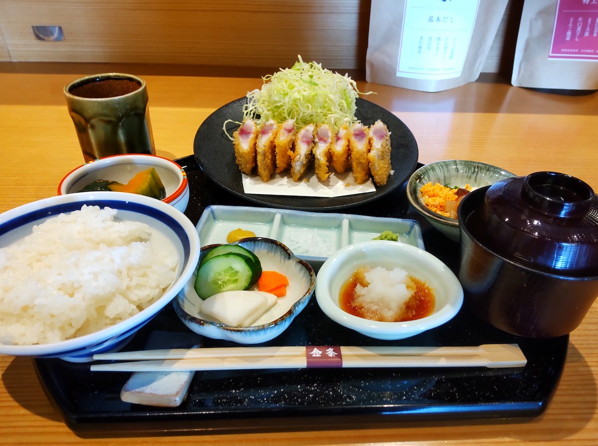 A Japanese meal set with sliced fried horse mackerel arranged in a row on a plate