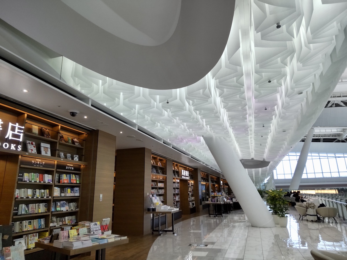 A seating area with a large pillar located right next to a bookstore