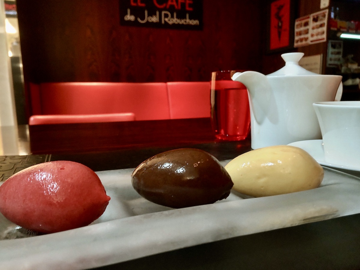 Glossy red, brown, and white ice cream with a red interior in the background