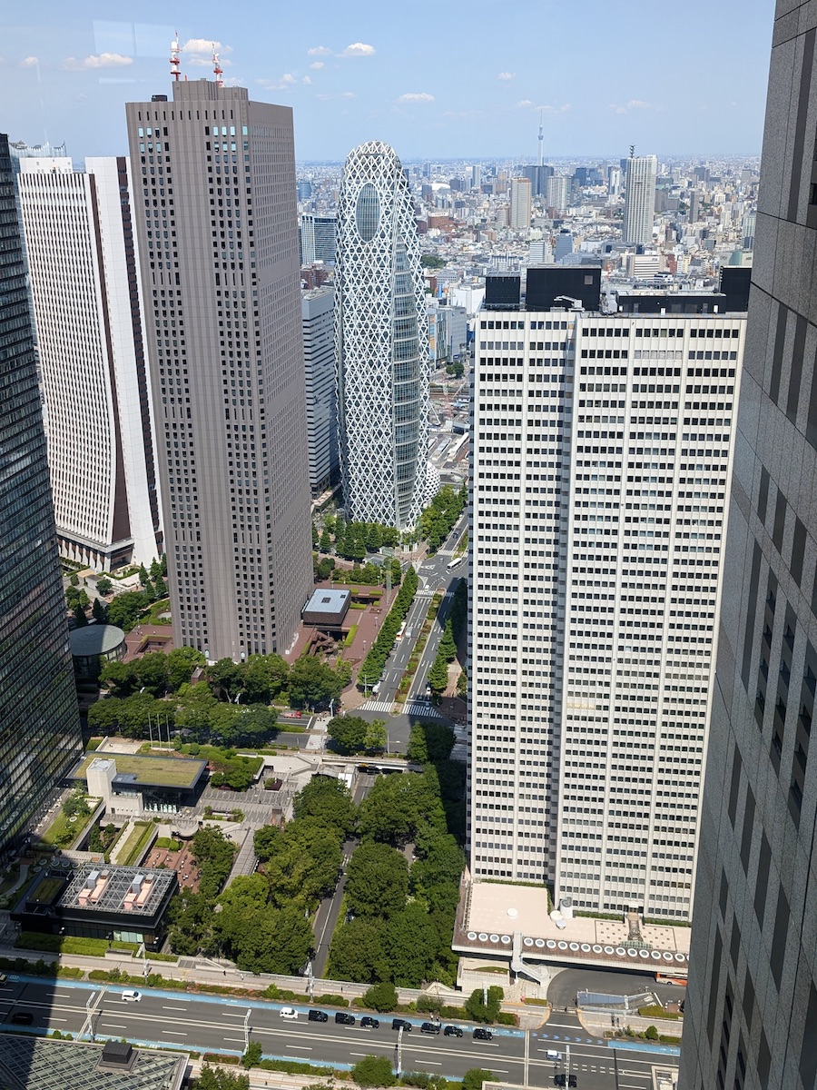 A cityscape view from an observation deck featuring the Cocoon Tower and Tokyo Skytree