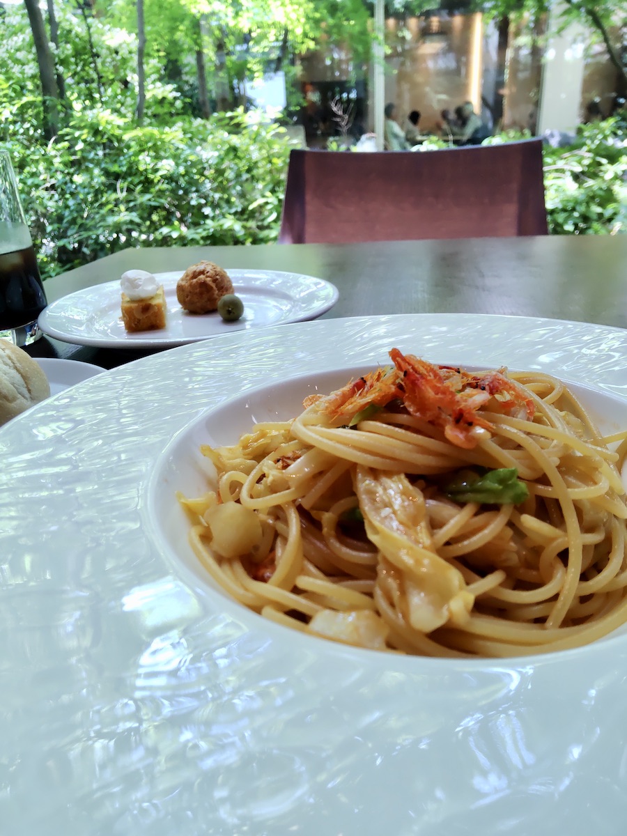 Sakura shrimp and cabbage pasta with assorted appetizers in background