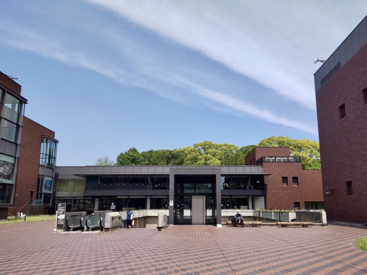A low dark red building standing under a clear blue sky