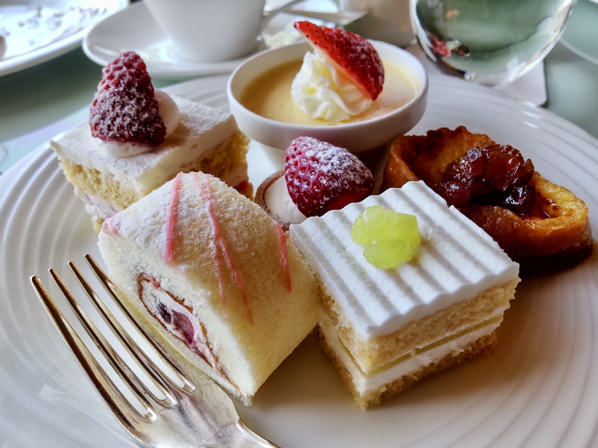 Close-up of numerous caks topped with fresh strawberries and melons