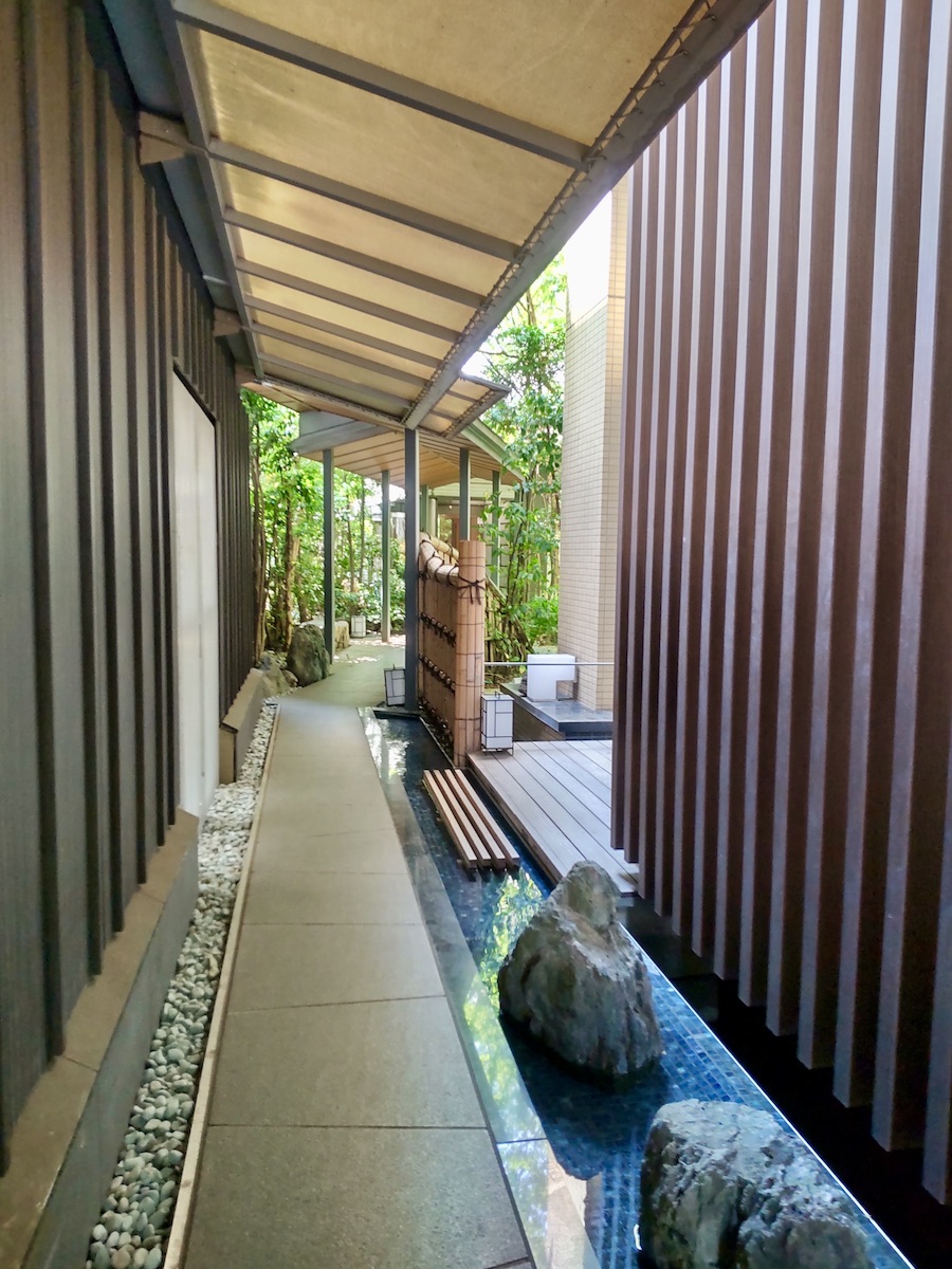 A modern Japanese-style walkway with rocks and a narrow stream