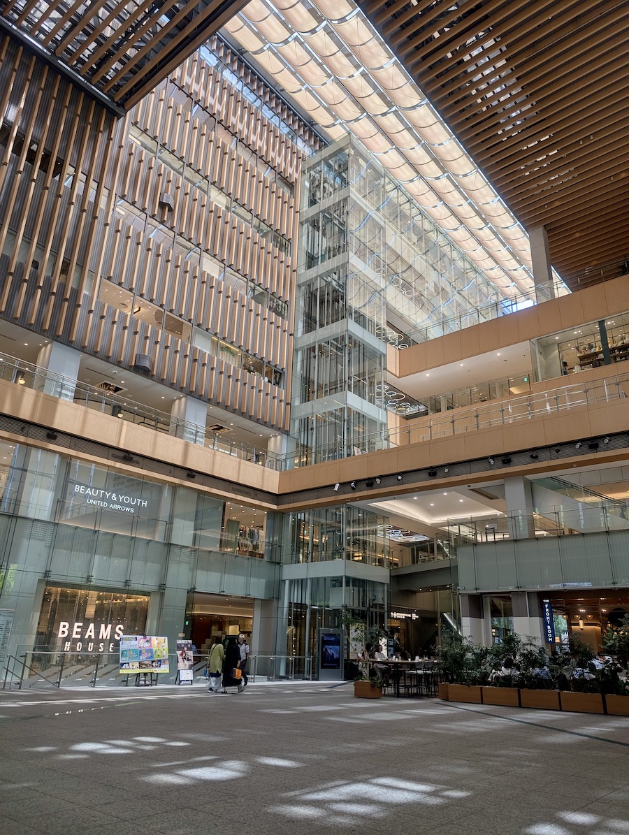An open-ceiling lobby with a sail-like ceiling and streaming natural light