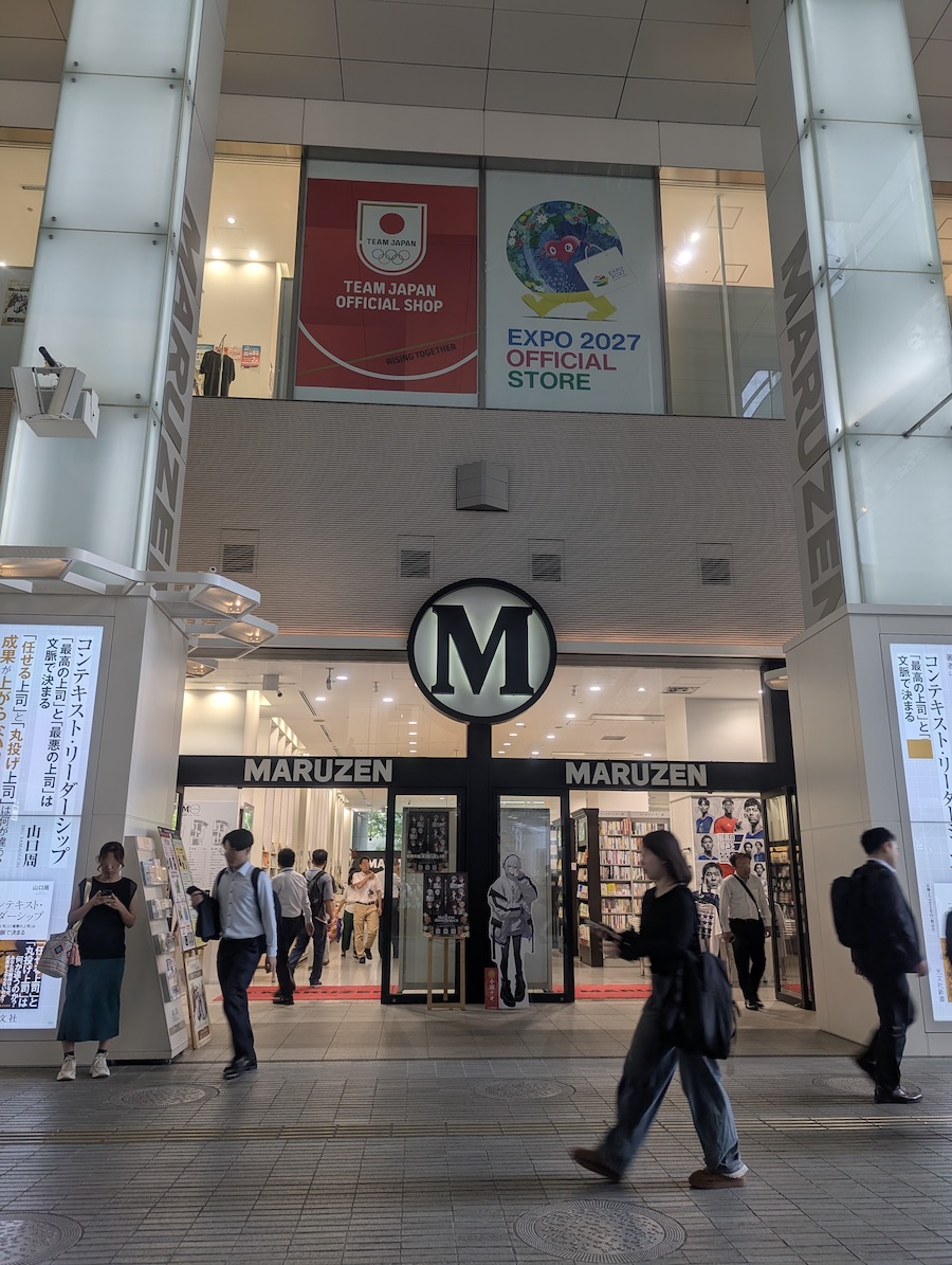 A large glass entrance featuring a prominent 'M' sign in the center