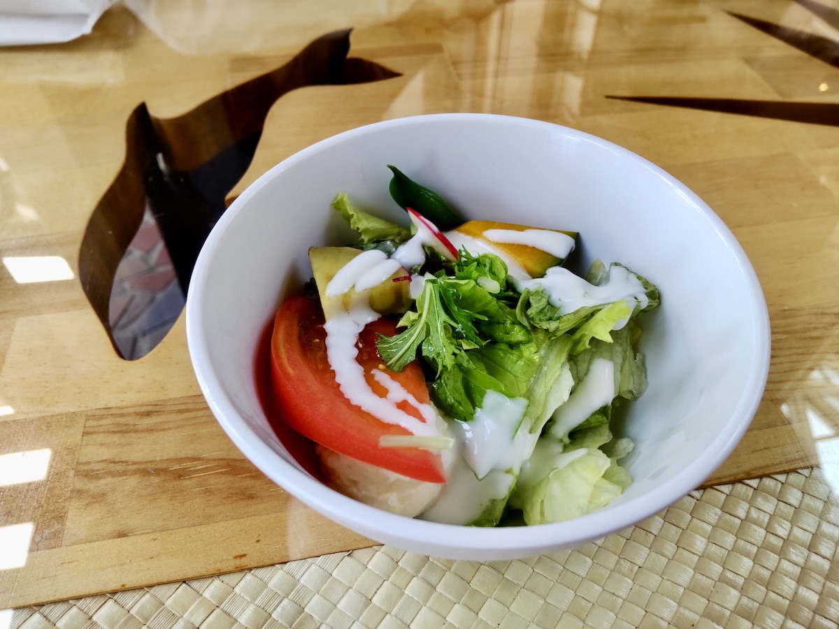 A fresh green salad drizzled with creamy white dressing