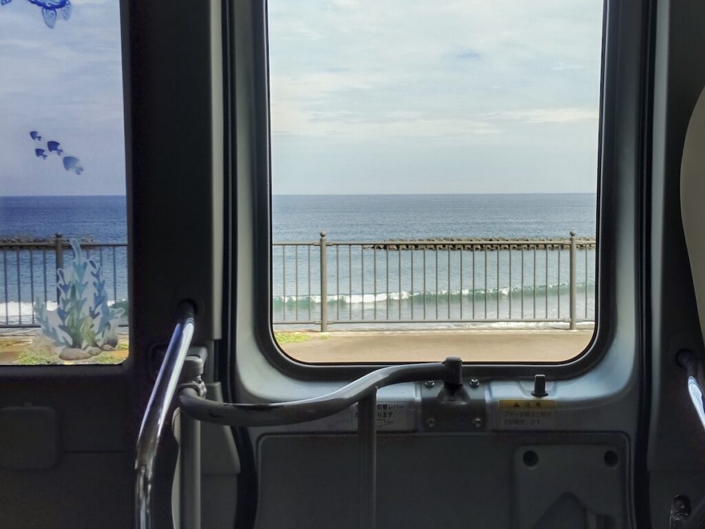 A view of a wavy beach seen through a car window