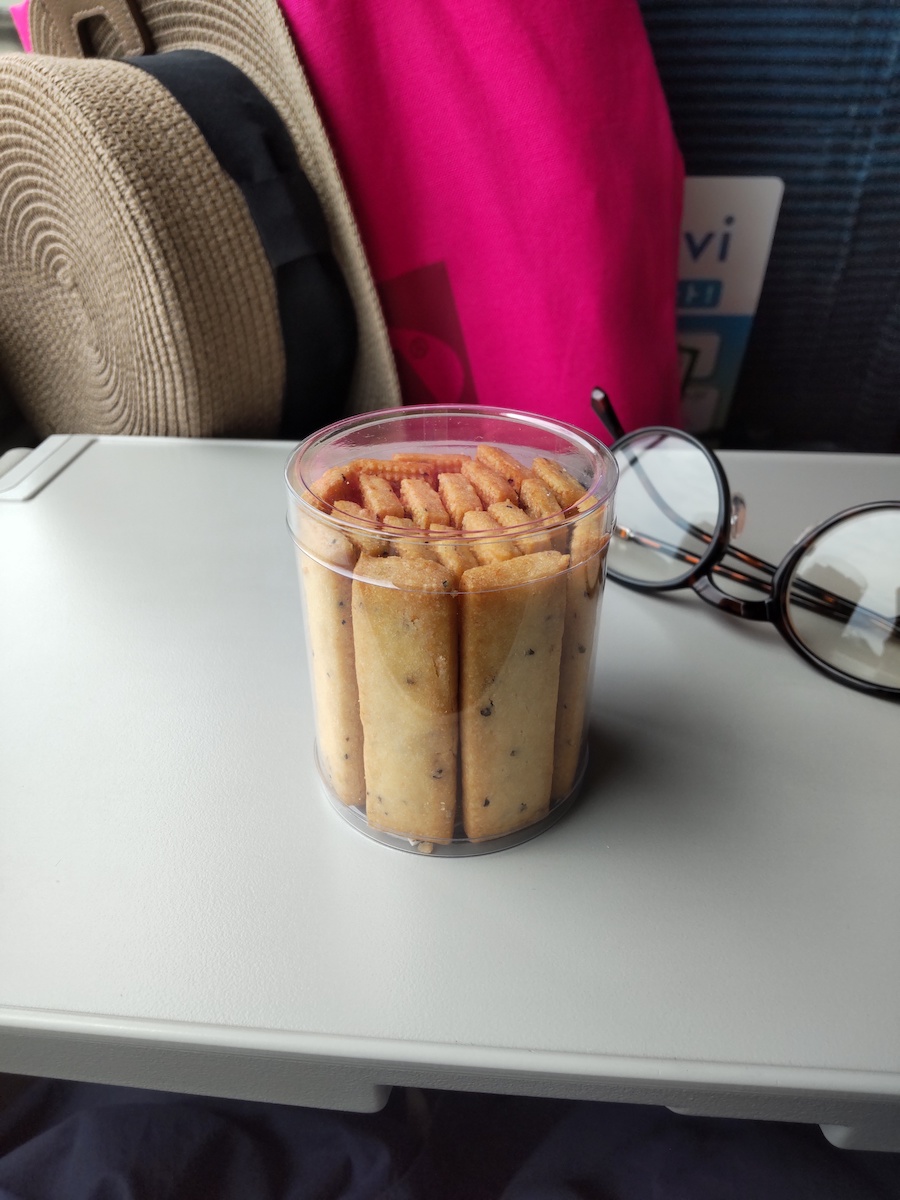Rectangular cookies packed neatly inside a small, clear cylindrical container