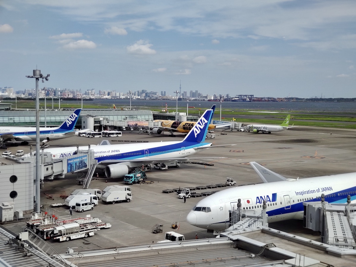 Airplanes at Haneda Airport with Tokyo Skytree and cityscape in the distance