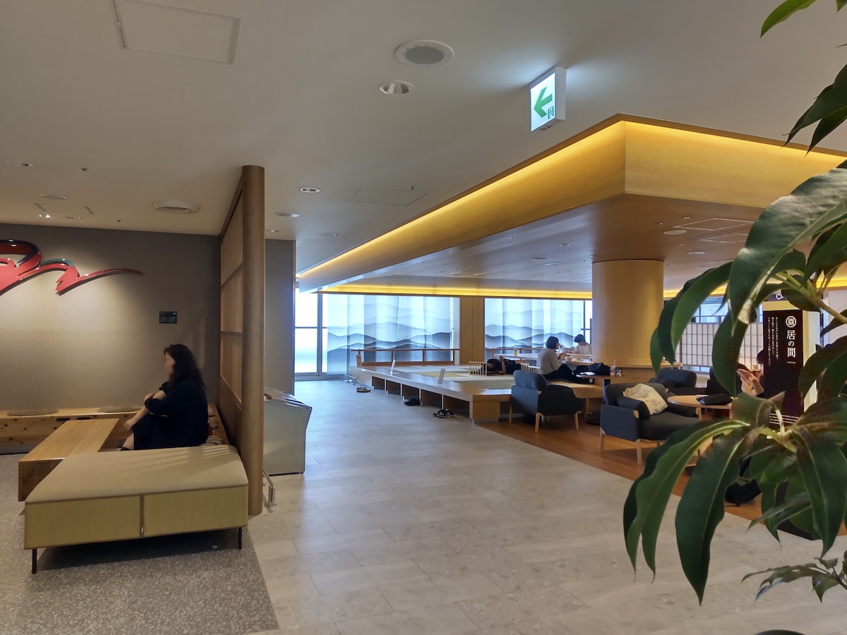 A modern Japanese-style airport waiting area with a tatami platform and chairs