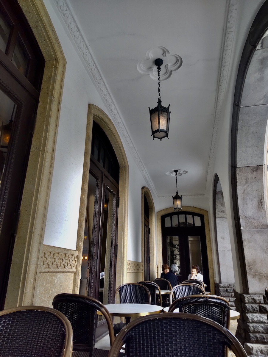 A beautiful loggia in a Western-style building with vintage hanging lamps and seating