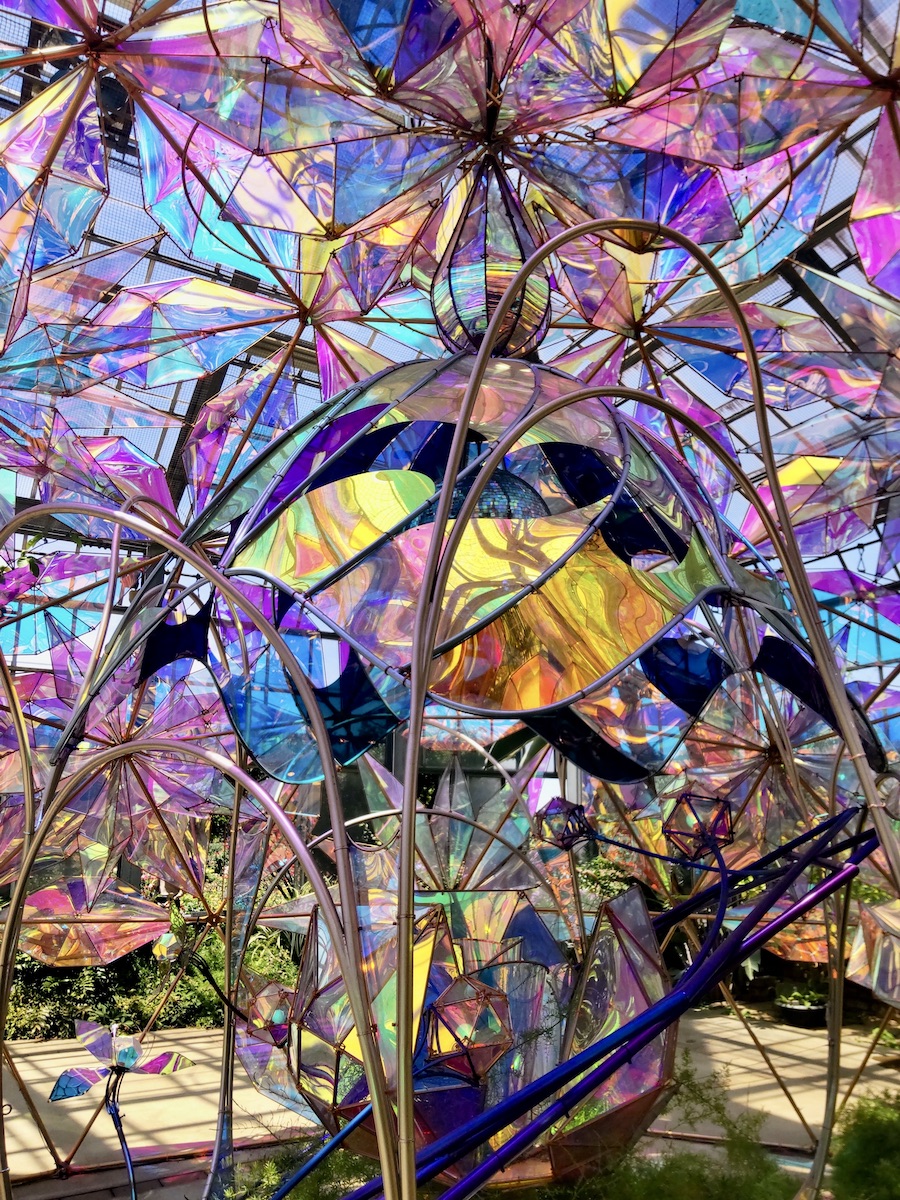 A beautiful dome structure made of colorful, translucent materials reflecting bright sunlight