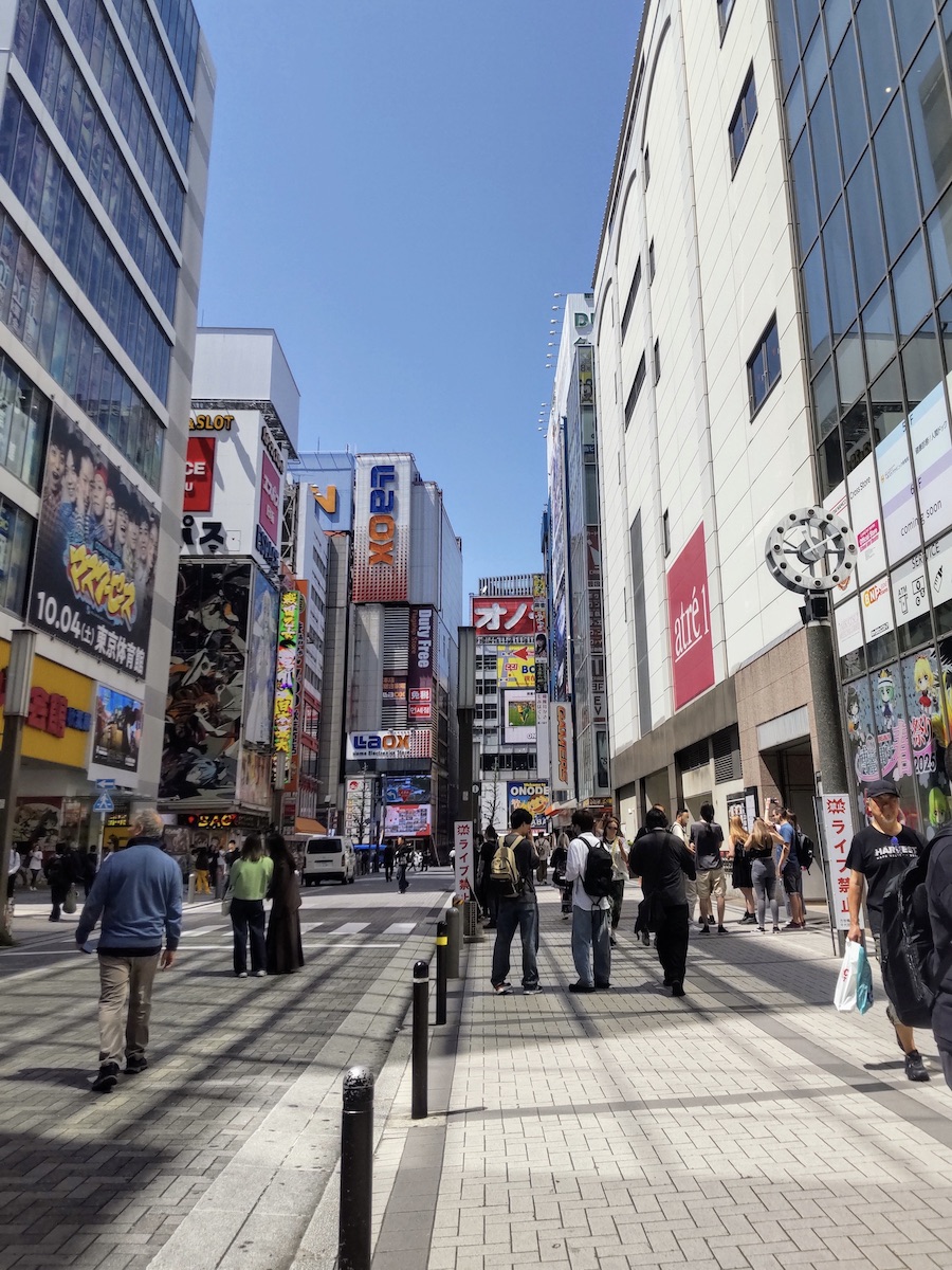 Busy street in Akihabara electric town surrounded by tall commercial buildings