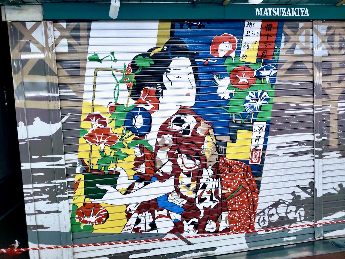 A colorful ukiyo-e style mural painted on a shop shutter in Asakusa