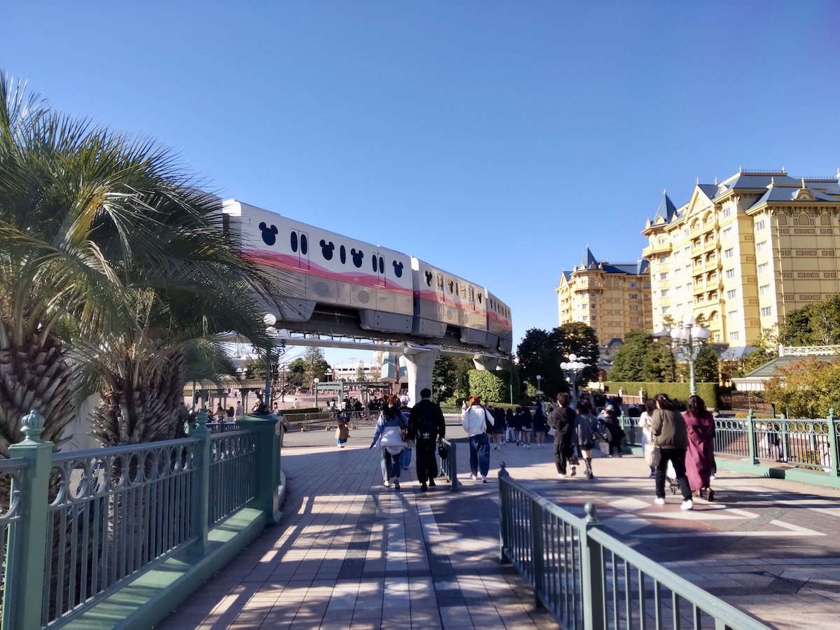 Disney monorail passing above a bridge with Tokyo Disneyland Hotel in the background