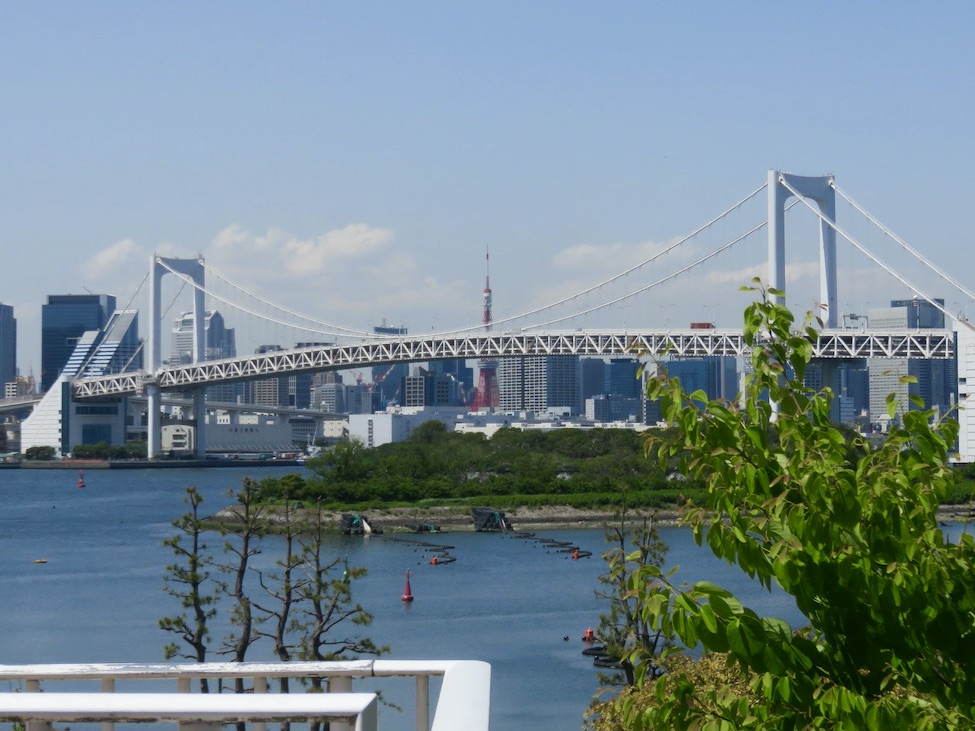 Rainbow Bridge stretching across Tokyo Bay with Tokyo Tower in the background