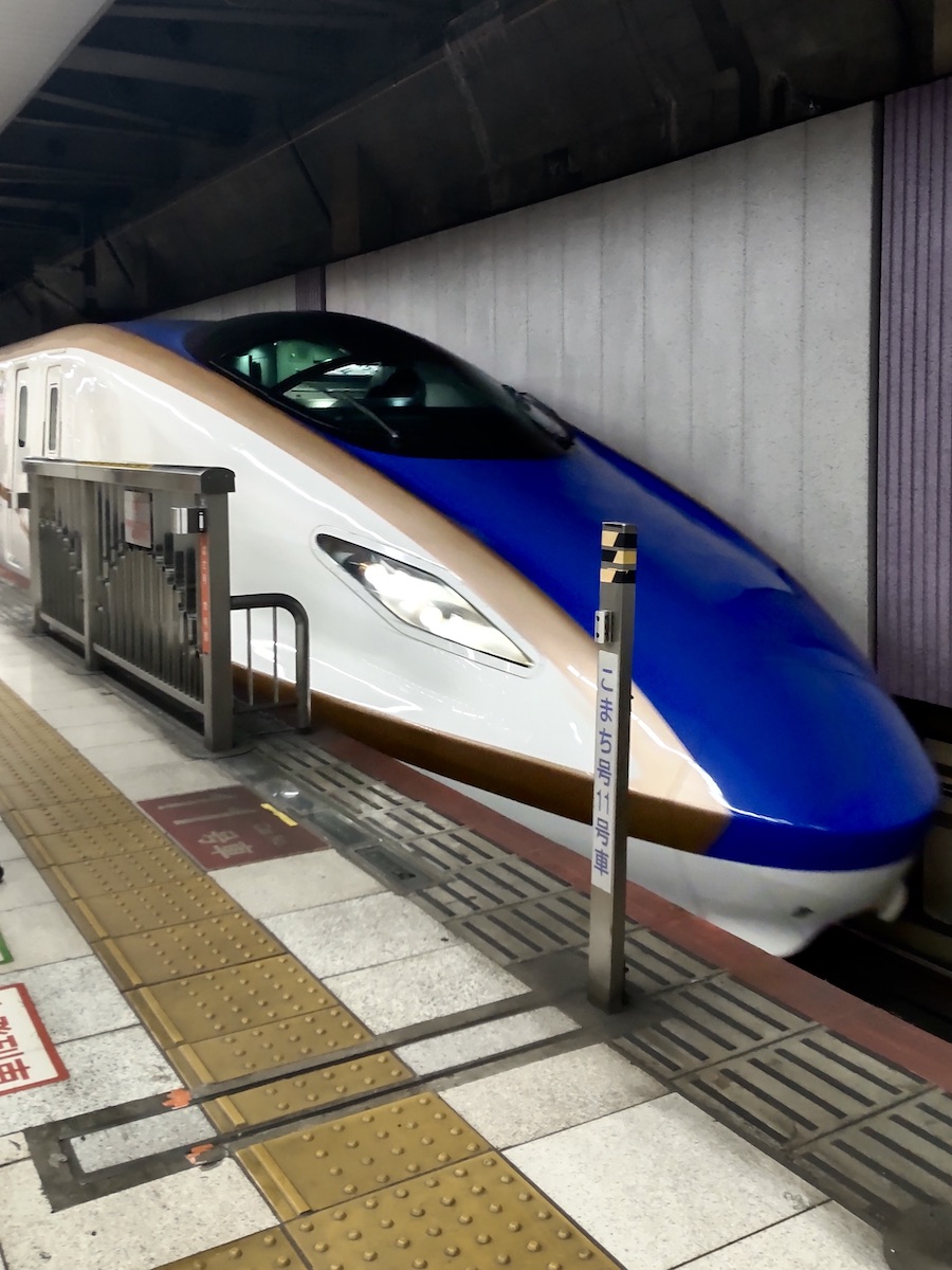 Blue and gold high-speed bullet train waiting at the station platform