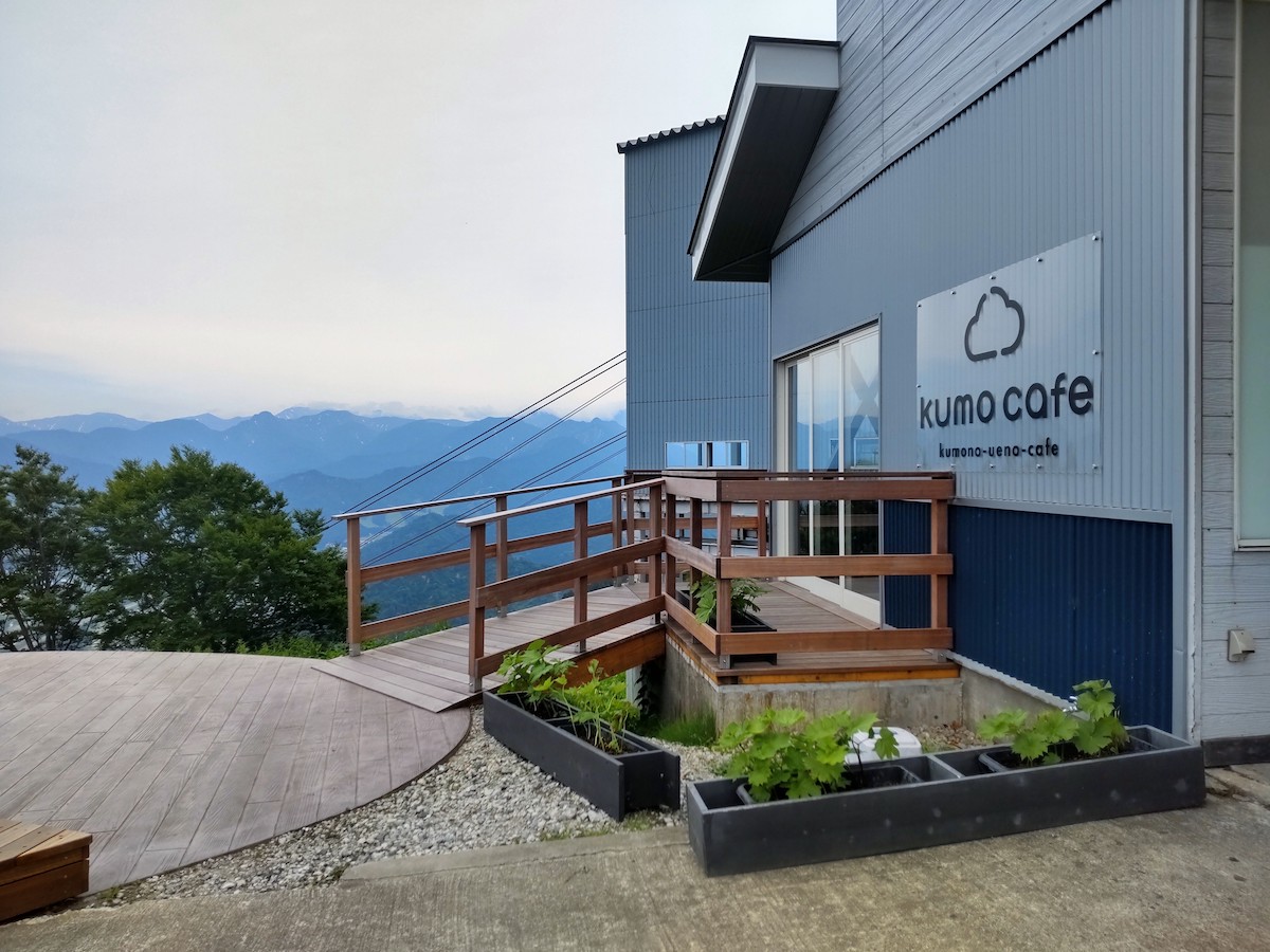 Modern cafe building named Kumo Cafe situated on a scenic mountain ridge