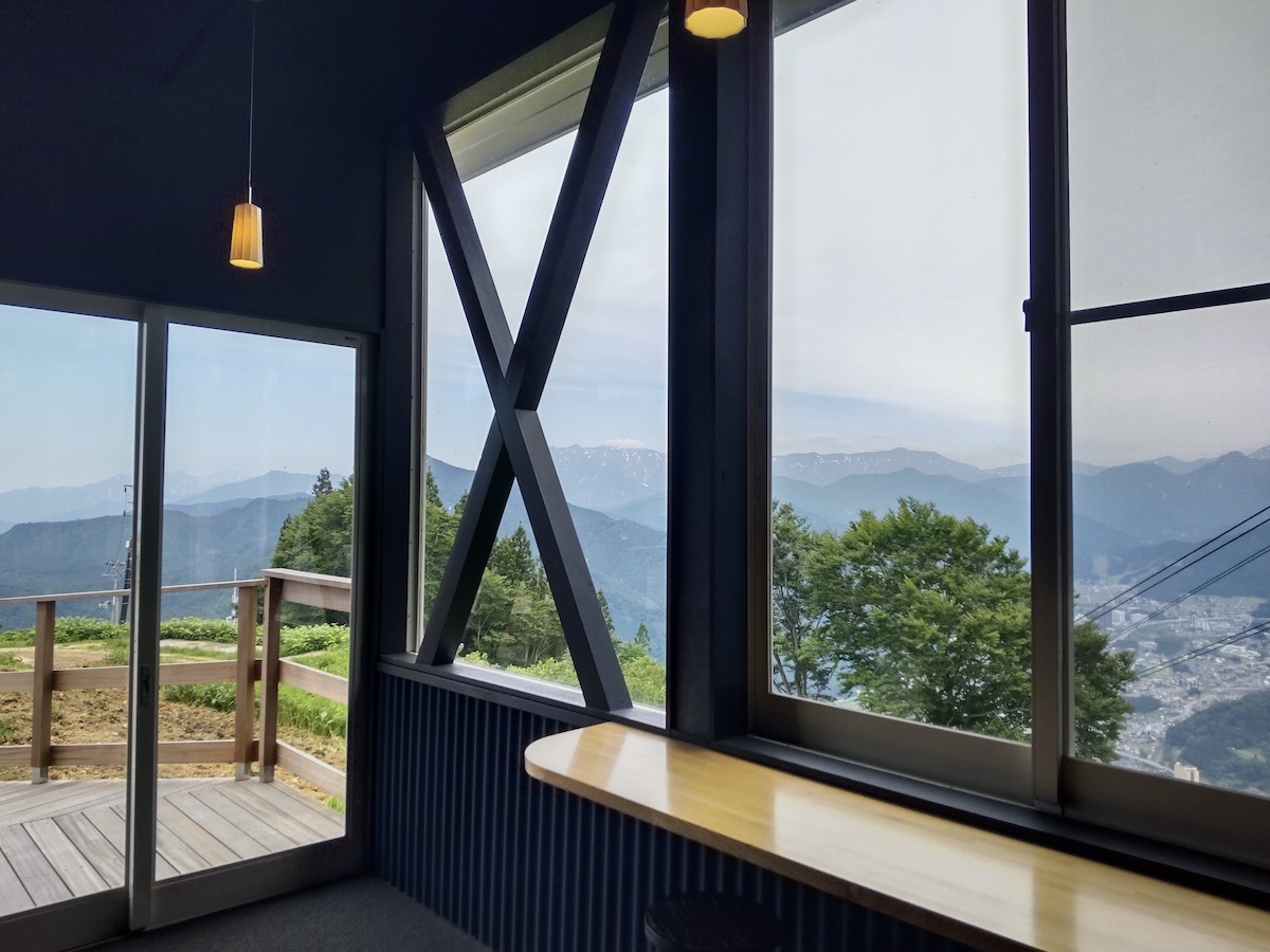 View of distant mountains from inside a modern cafe with large glass windows