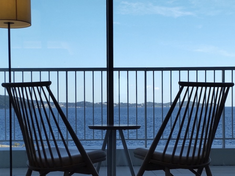 Two natural chairs placed in front of a beautiful ocean view