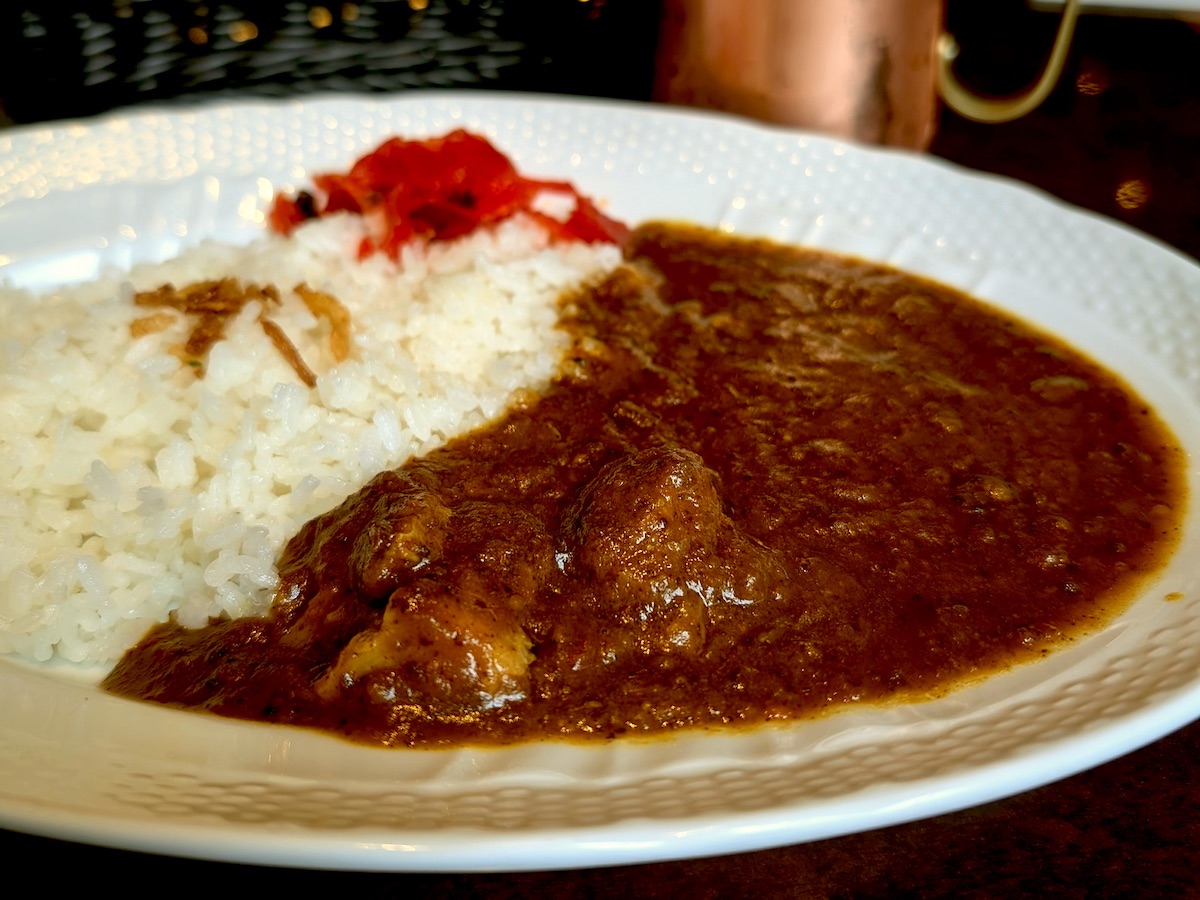 Savory curry rice with tender meat served on white plate at cafe