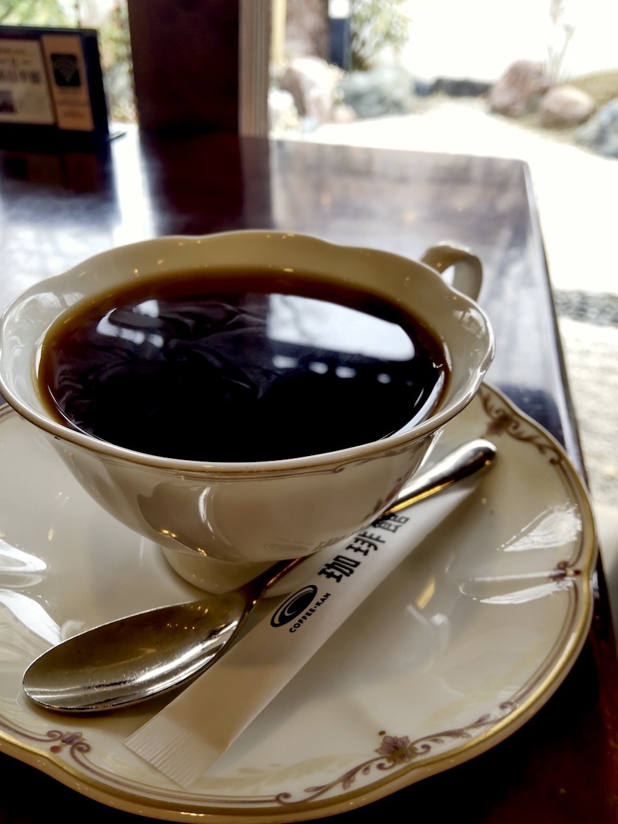 Hot coffee served in classic porcelain cup on table at traditional cafe