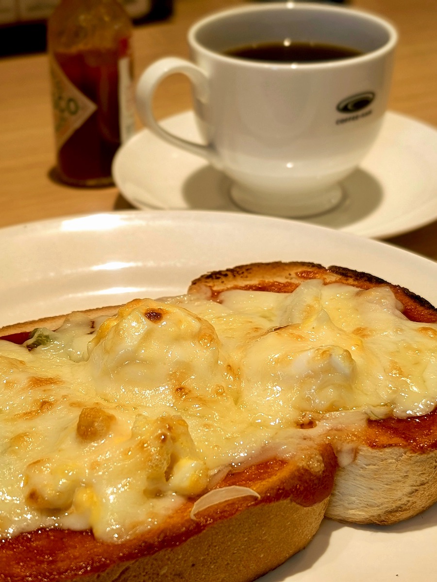 Freshly baked pizza toast with melted cheese served with hot coffee