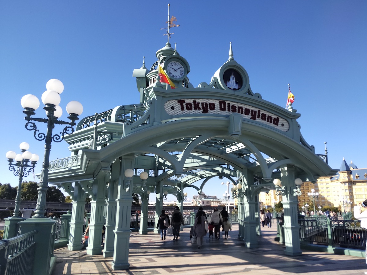 Decorative entrance archway of Tokyo Disneyland Station against a clear blue sky