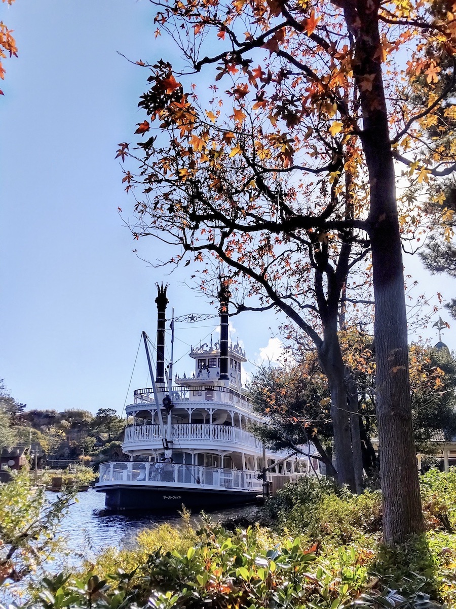 Scenic view of a majestic paddle steamer behind colorful autumn trees