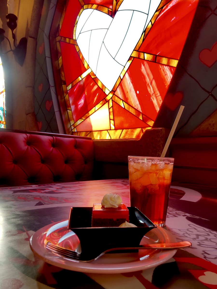 Cake and iced tea served before a glowing heart stained glass window