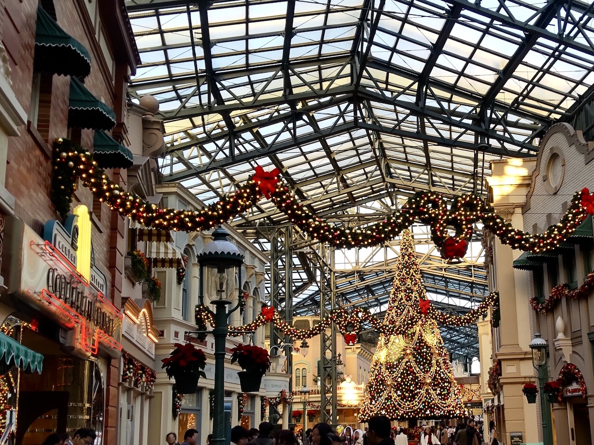 Illuminating Christmas garlands stretching along World Bazaar street leading to tree