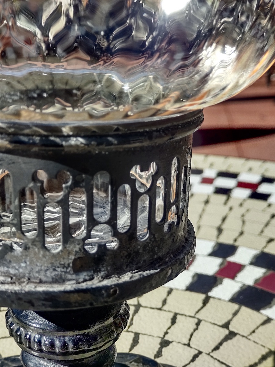 Close-up of a vintage glass lamp featuring subtle Mickey Mouse icon cutouts