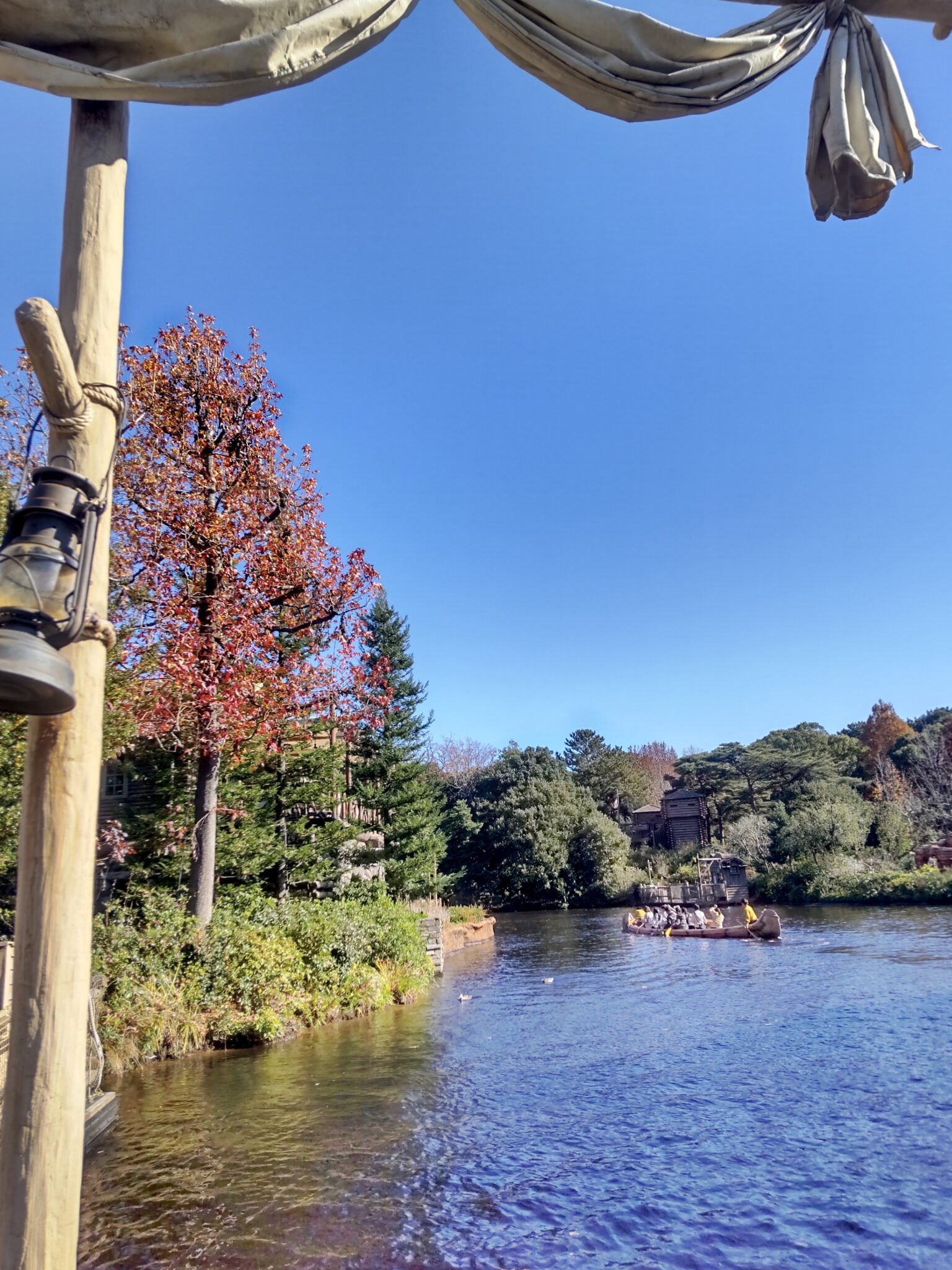 Scenic river view from a boat with autumn trees and clear blue sky