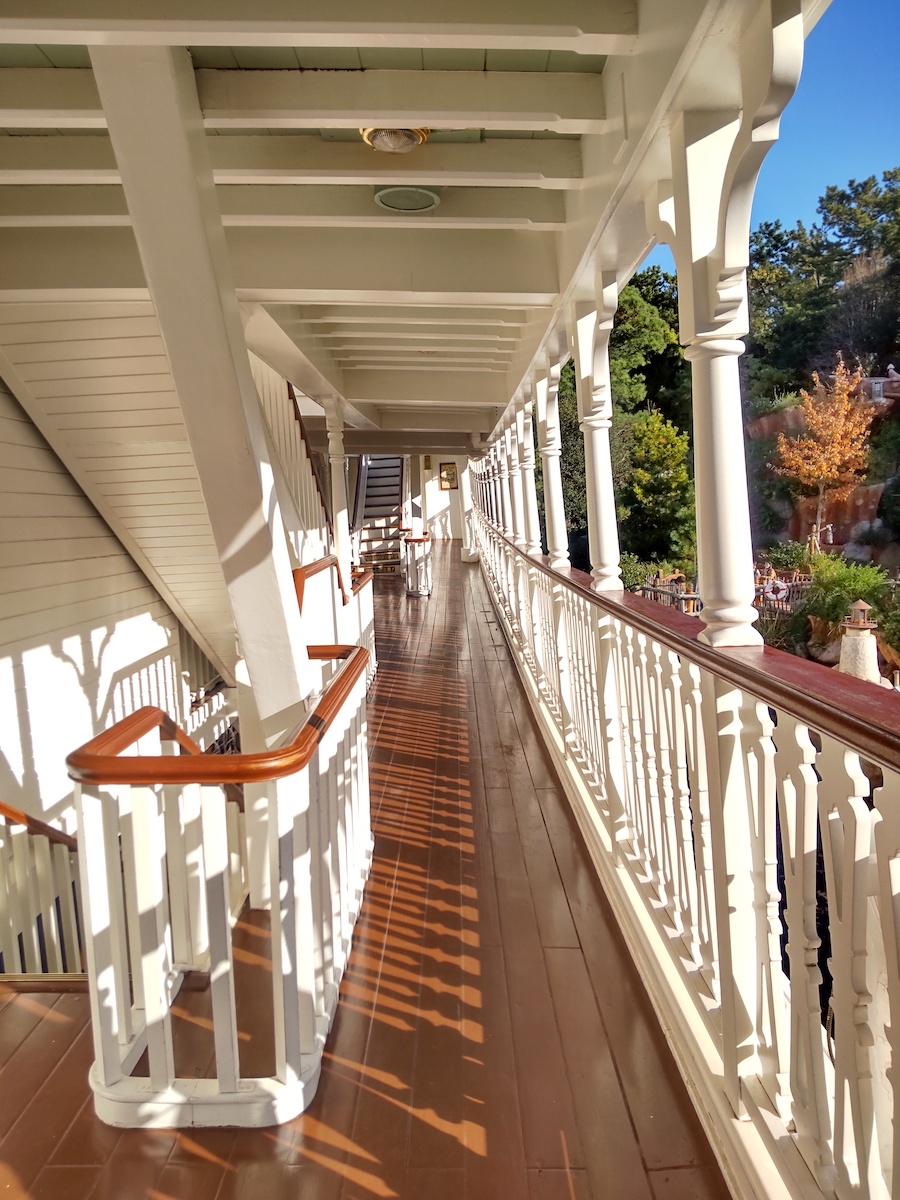 White elegant railings along a quiet steamboat promenade bathed in afternoon light